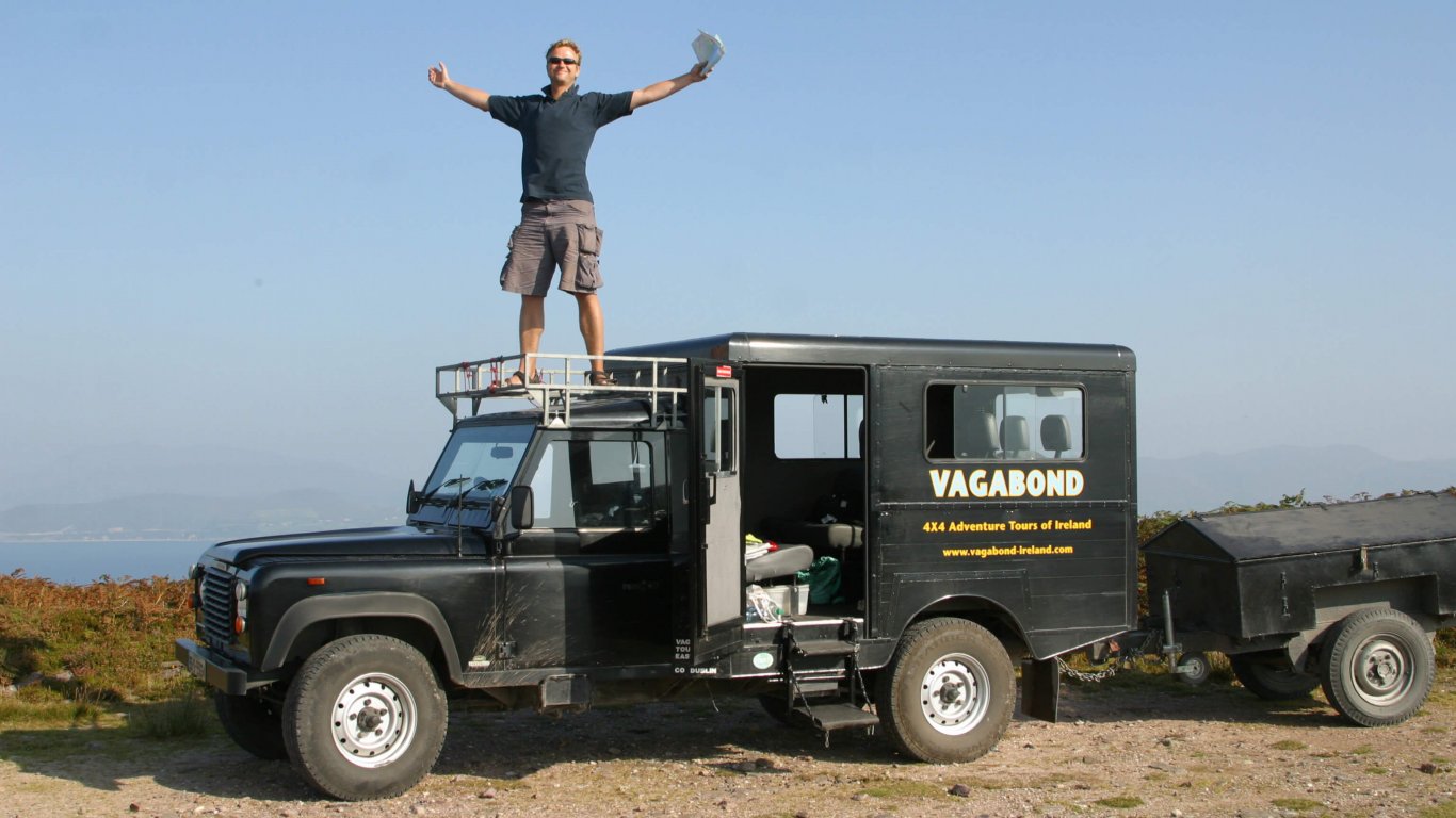 Rob Ranking standing on top of a Vagabond Tours Land Rover Defender in Ireland