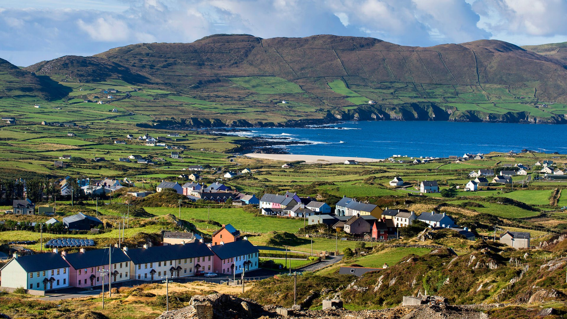 Scenic green fields, quaint village and ocean at Allihies on the Beara Peninsula in Ireland
