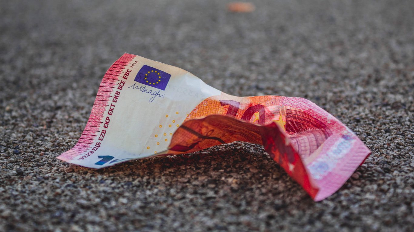 A crumpled 10 euro note on the tarmac