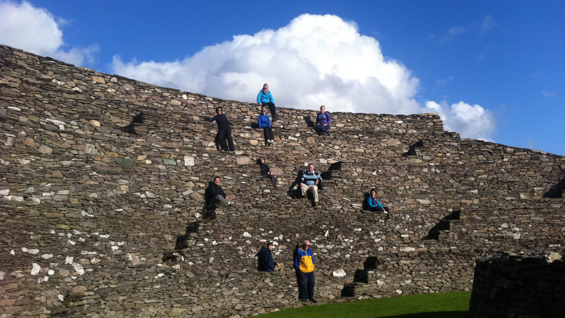 A tour group exploring the Giranán of Aileach stone fort and standing on the different levels