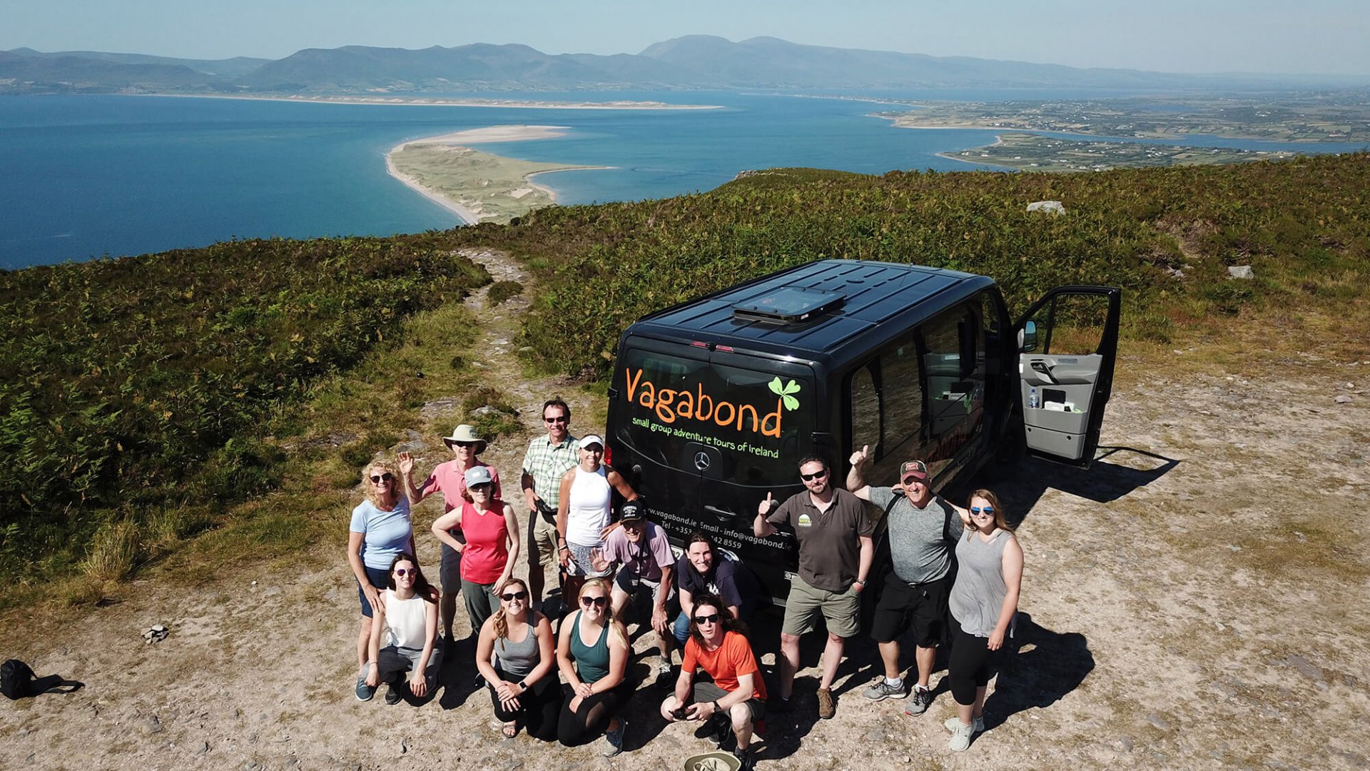 A Vagabond group posing in front of their Vagatron looking over Rossbeigh beach on the Iveragh peninsula