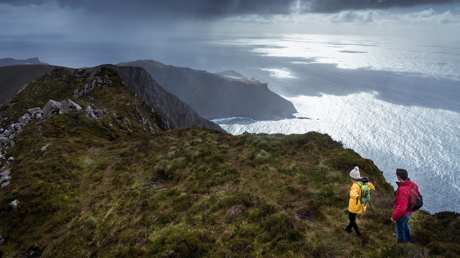 A couple hiking along the Slieve League cliffs with a magnificent view of the Atlantic Ocean