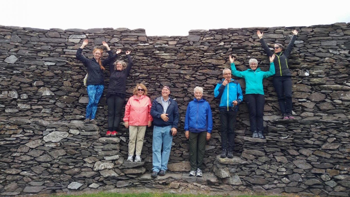 Group of Vagabond tour passengers posing on Cahergal stone fort walls