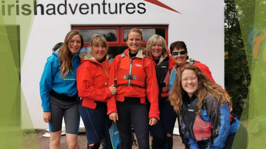 Female tour guests with Vagabond tour guide smiling at a kayaking centre
