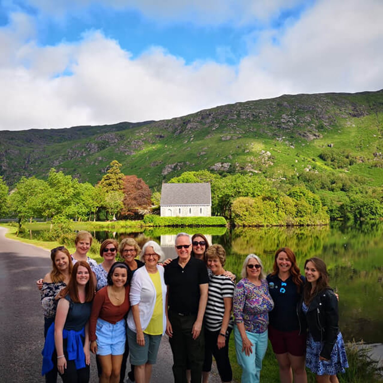 A Driftwood group taking a group photo in front of the lake at Gougane Barra