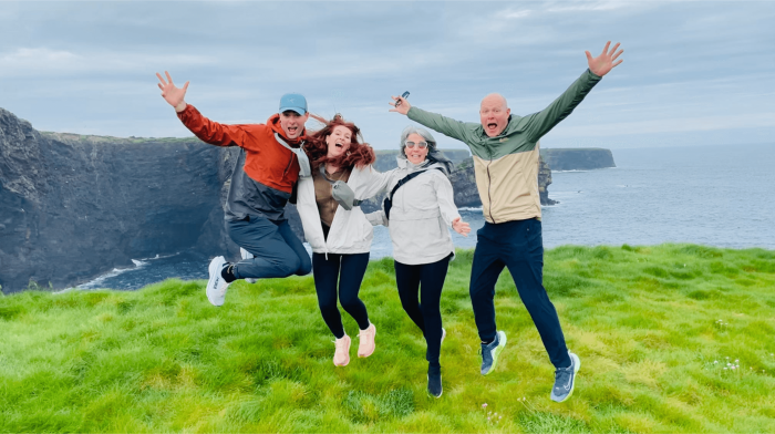 Marvel at the breathtaking beauty of the Cliffs of Moher A group of guests jumping and laughing at the cliffs of moher