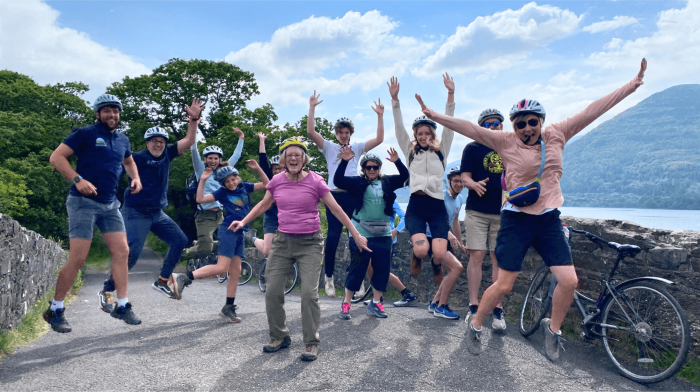 Embark on a guided cycling adventure through Killarney National Park A group jumping for joy in Killarney National Park on their cycling tour