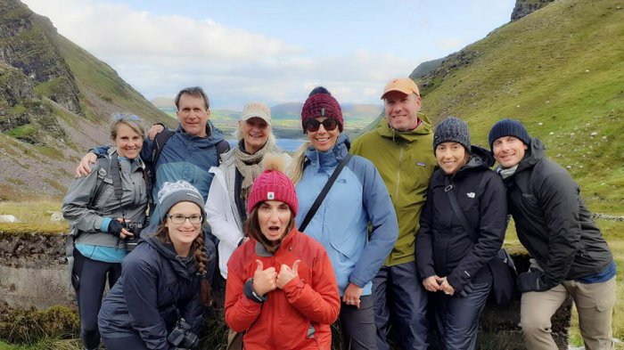 Savor the fresh air and stunning views as you hike with your fellow guests A group of Vagabond guests hiking in Annascaul Valley