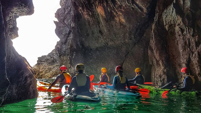 Sea kayak off the remote coast of Donegal a group of kayakers exploring a sea cave
