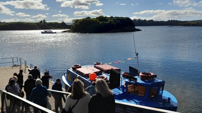 Guests boarding boat with island in background on Wild Atlantic Way tour of Ireland