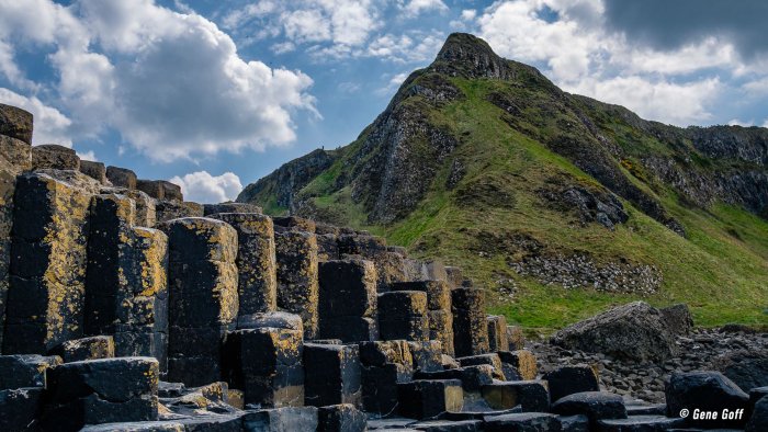 Explore the mystical Giant's Causeway Basalt columns of the Giant's Causeway wtih a mountain in the background