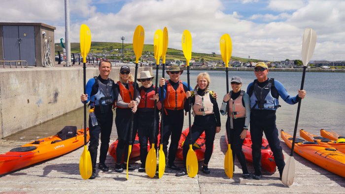 Preparing to paddle through Dingle's coastal wonders Seven guests waiting to go kayaking in Dingle Bay