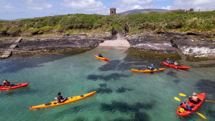 Paddle through paradise: Enjoy guided sea kayaking in Dingle Bay A group of kayakers on dingle bay with husseys folly in the distance