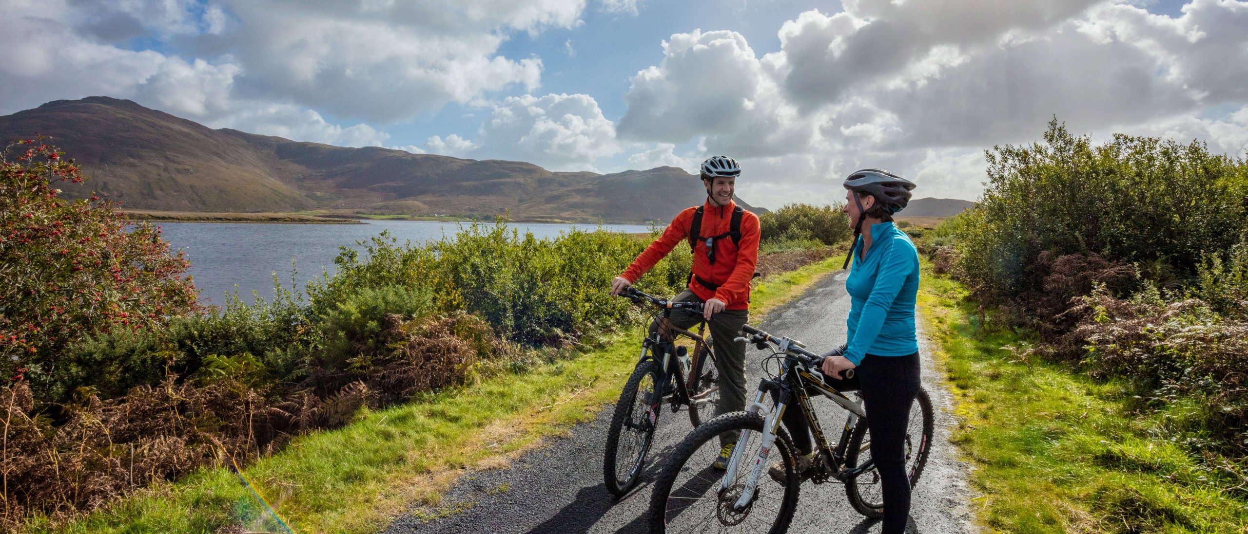 Couple cycling stop with their bikes at scenic spot on Great Western Greenway in Mayo