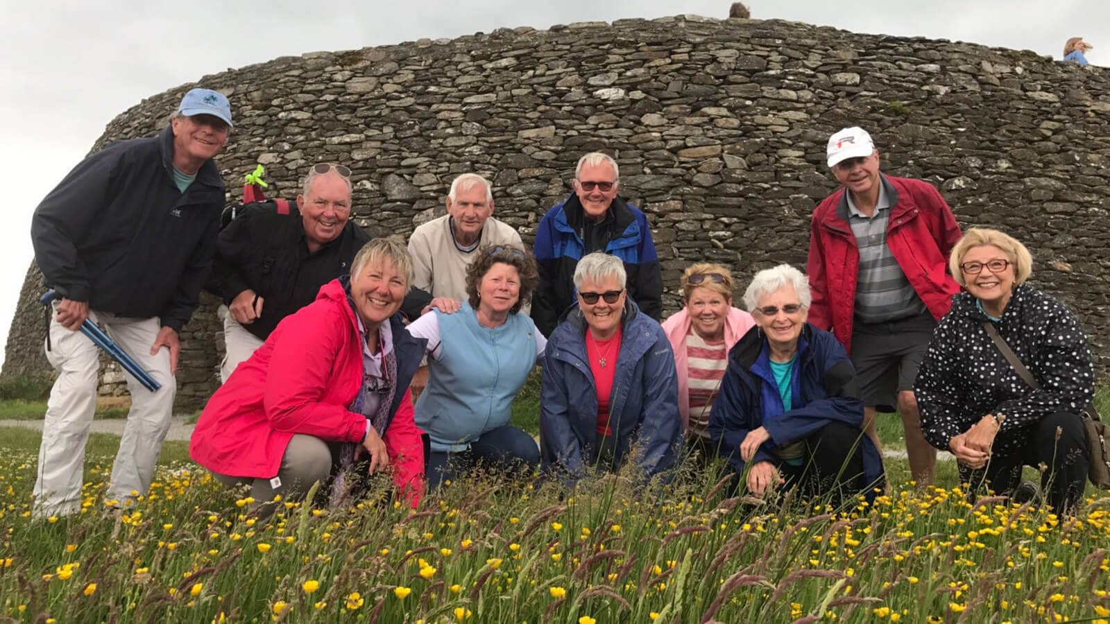 Smiling middle aged tour group at Grianan of Aileach in Ireland