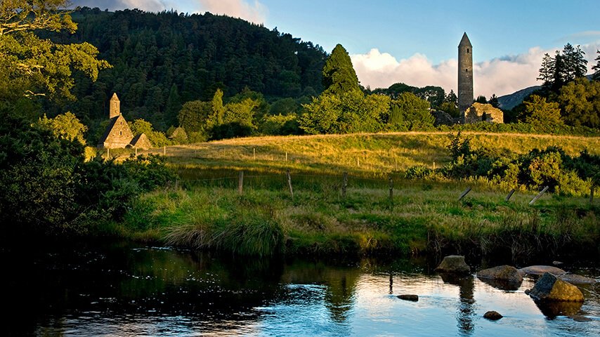 Tower and church near the river at Glendalough