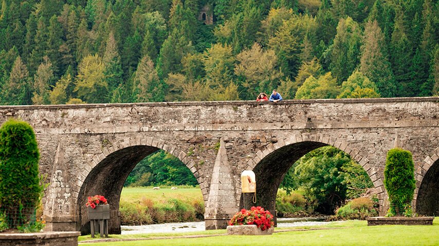 A couple gaze down from an arched bridge in Inistioge, Kilkenny
